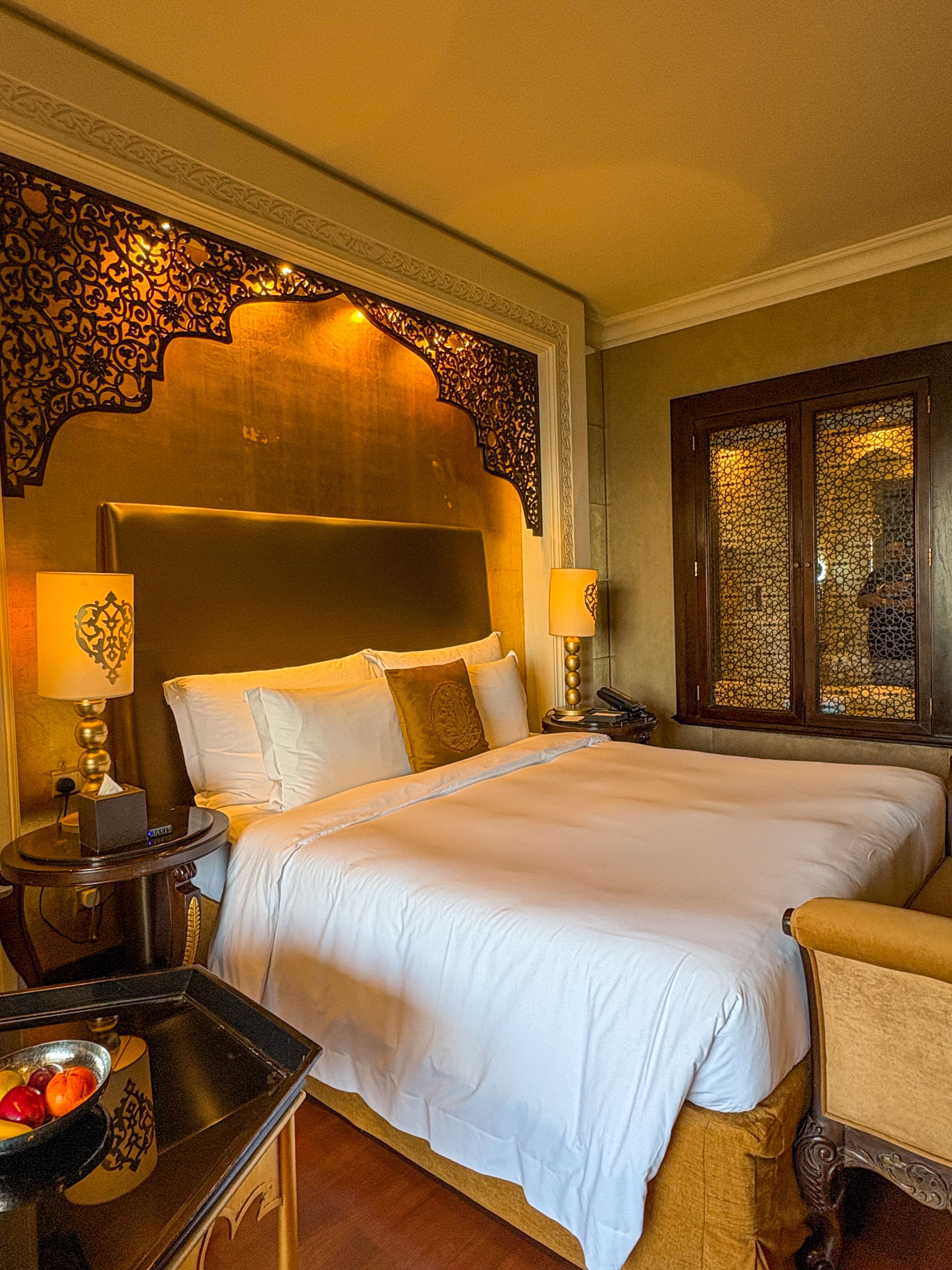Luxury hotel suite with ornate decor and plush bedding in Dubai