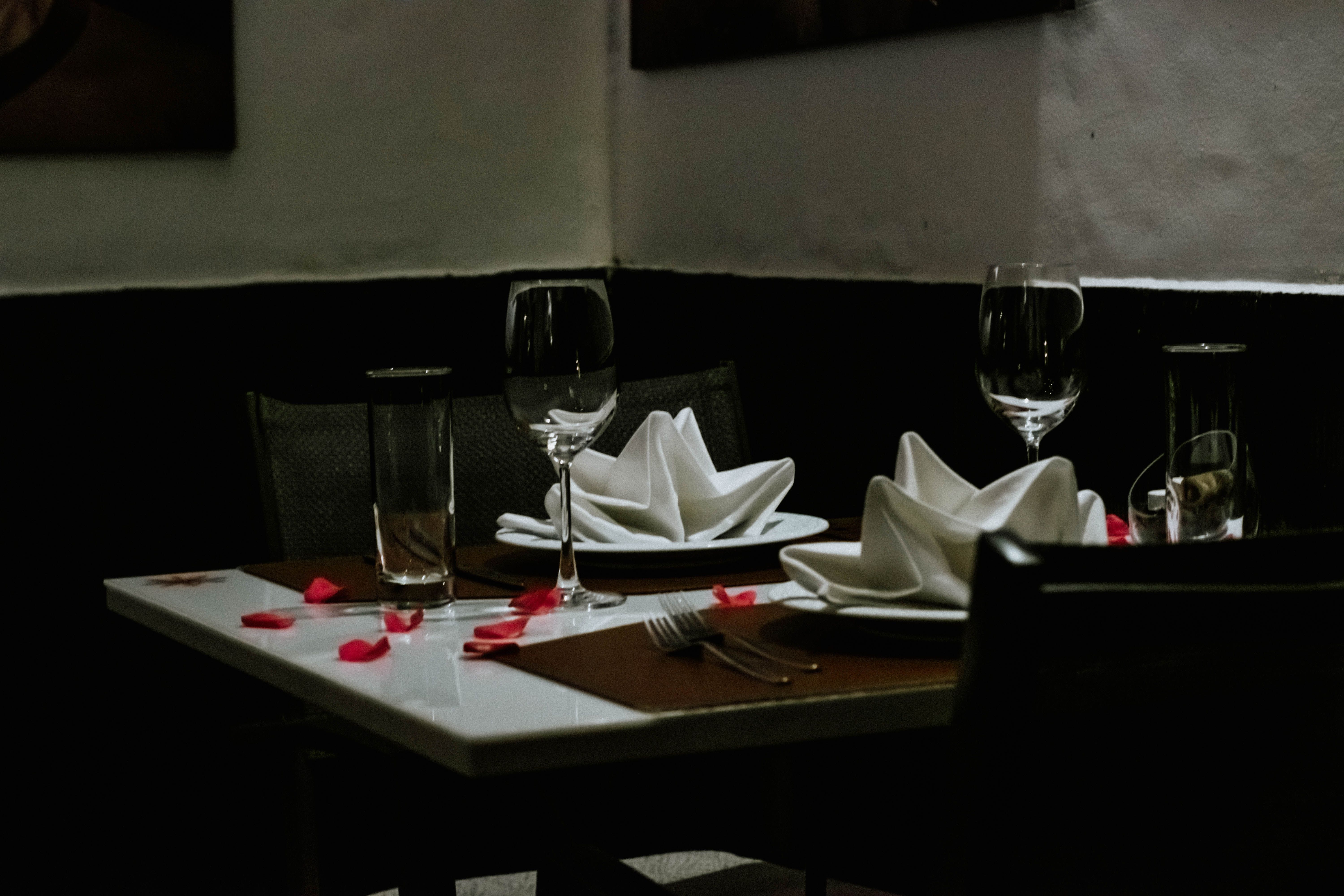 Romantically set luxury dinner table with napkins and wineglasses in an upscale ambiance
