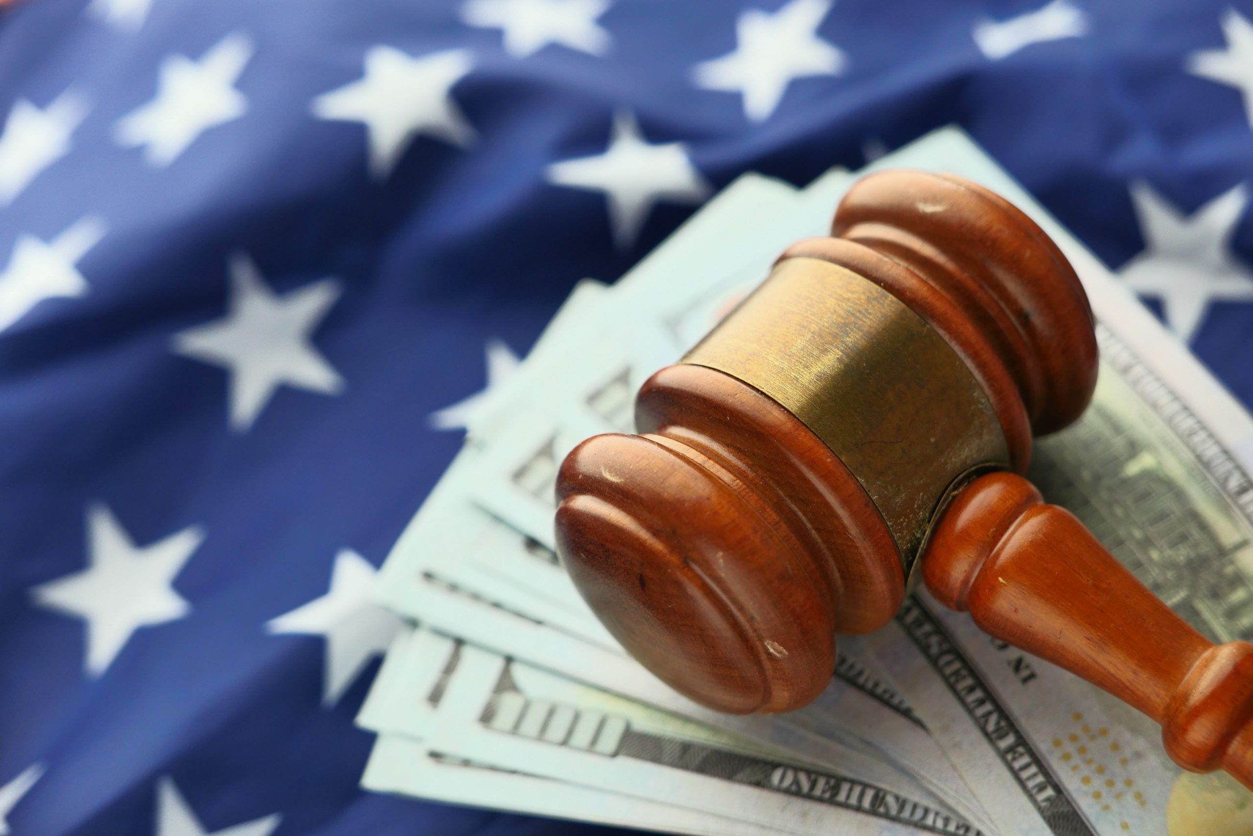 Gavel resting on US dollar bills with an American flag behind it, symbolizing the intersection of justice and litigation finance