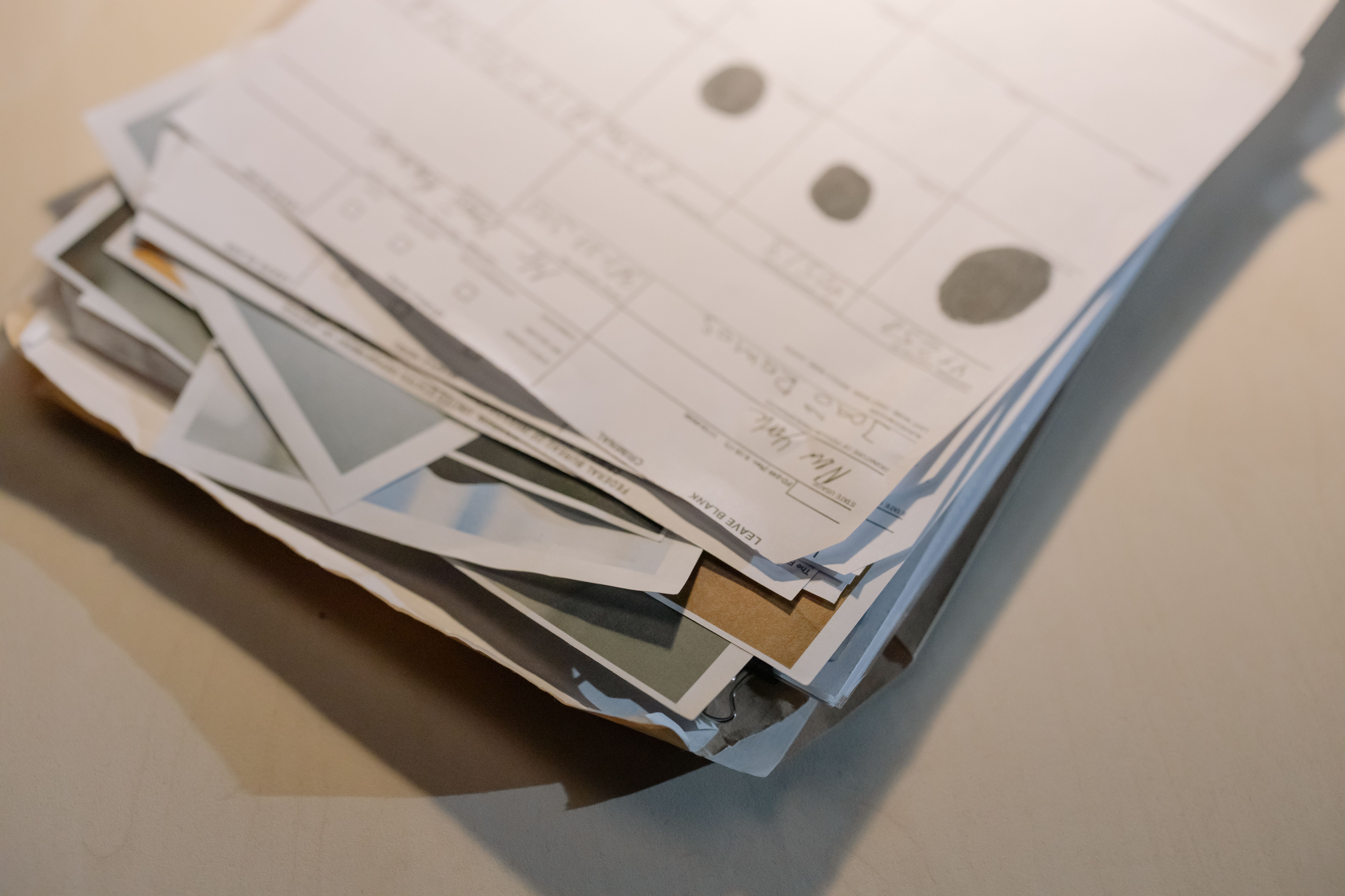 Close-up of a thick stack of legal documents and papers on a desk, representing the paperwork burden of large-scale litigation