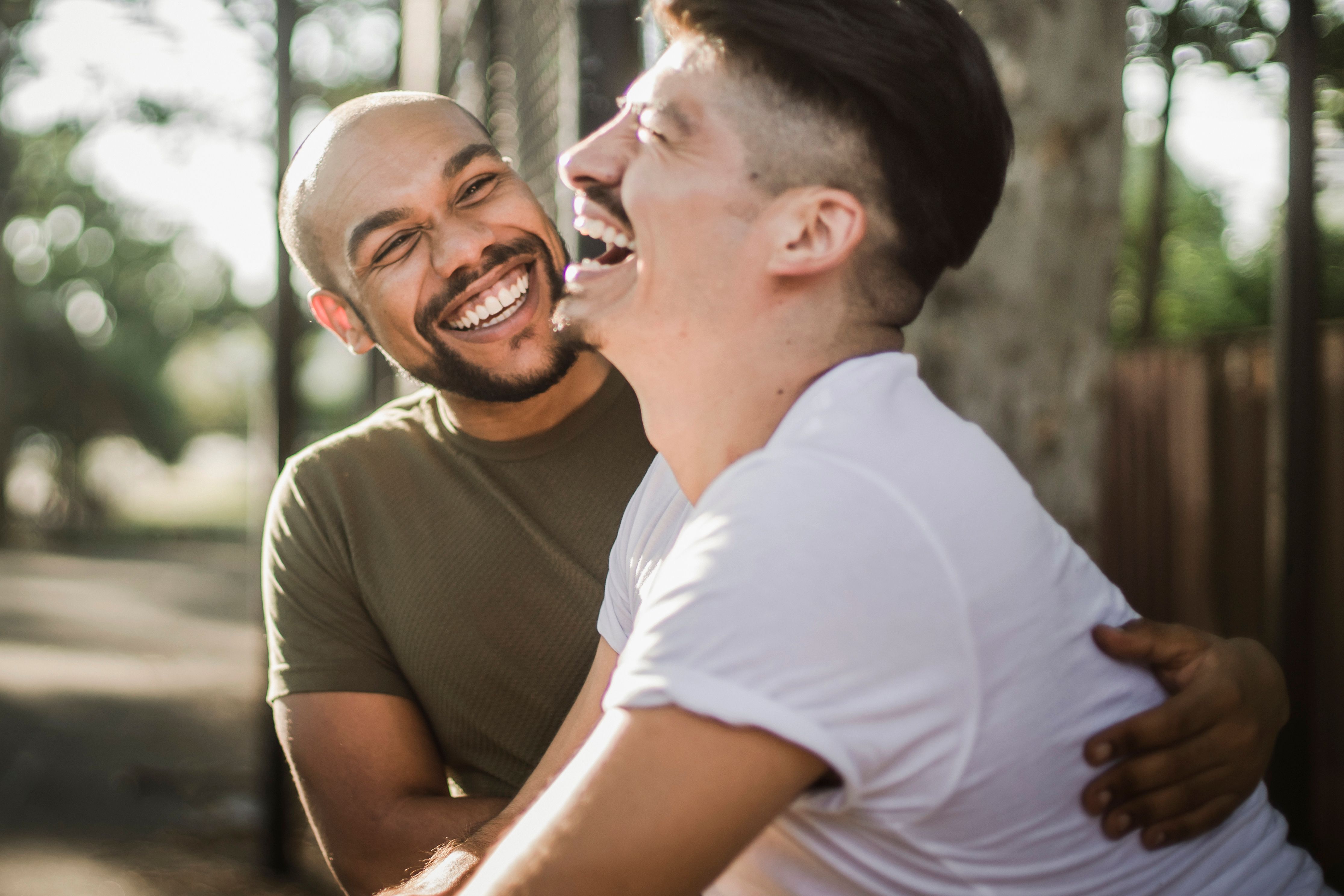 A happy couple laughing and embracing outdoors, suggesting the mood and relationship benefits of intimacy.